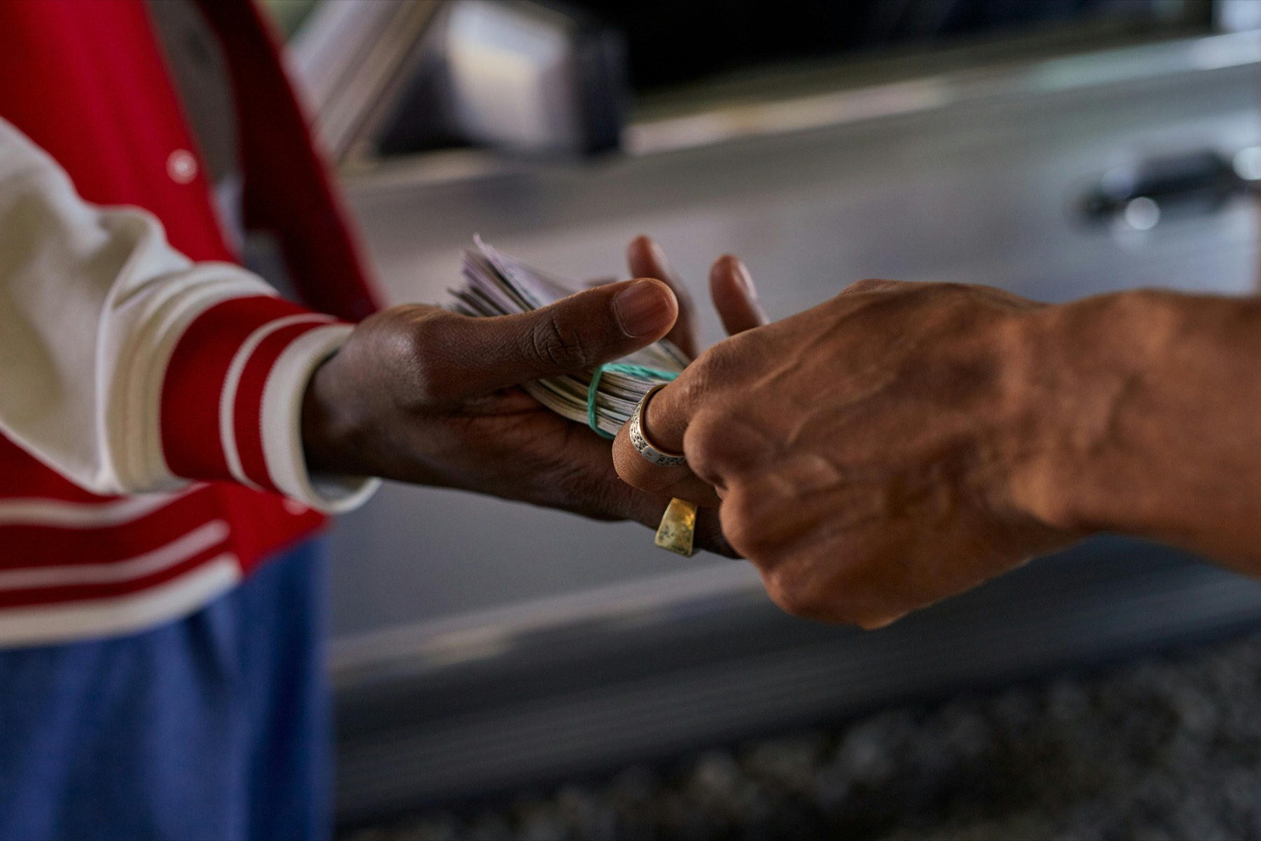 Customer receiving cash payment next to a vehicle